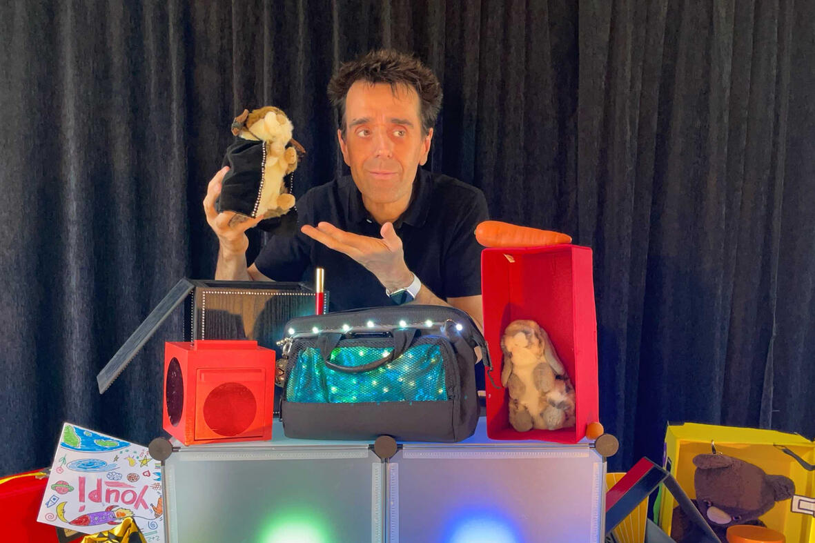 Zouick, fouick, Touick Monsieur Fred sur scène dans son décor imaginaire, présentant “Zouick, fouick, touick” à un jeune public émerveillé.